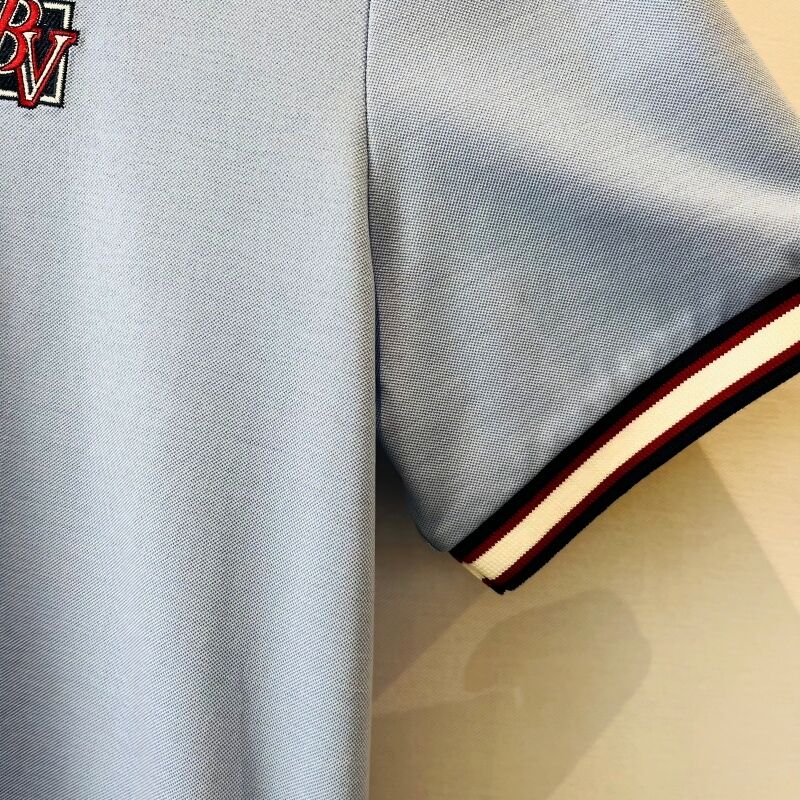 เสื้อโปโลสีน้ําเงินเบา ผู้ชาย มีคอขัดแย้ง & โลโก้ลายกระเบื้อง สไตล์ธุรกิจ-ประจํา เสื้อโปโลสีพีเก้ ผู้ชาย